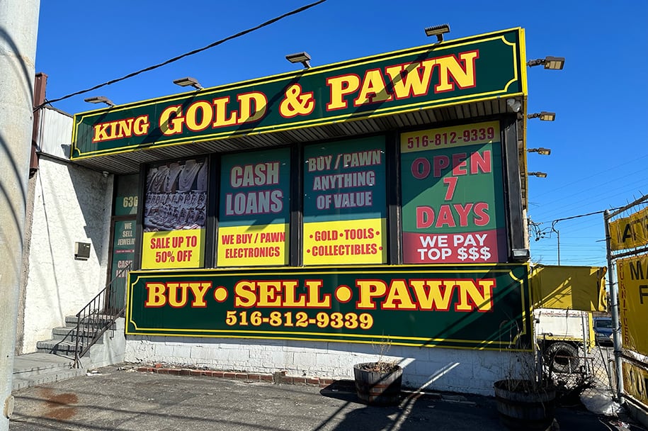 King Gold & Pawn shop at 636 Rockaway Turnpike in Lawrence, NY. Shop front with black and gold signs offering cash loans.